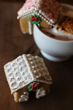 two waffles with christmas decorations on them sitting next to a bowl of hot chocolate