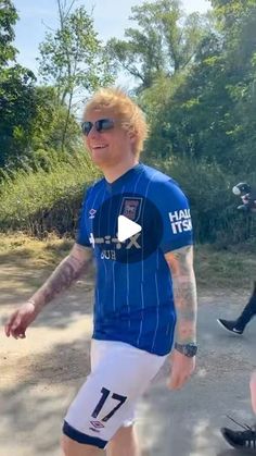 a man in blue shirt and white shorts playing soccer