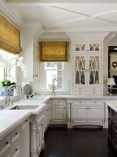 a kitchen with white cabinets and wood floors