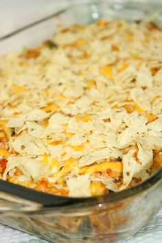 a casserole dish with cheese and meat in it on a white tablecloth