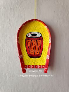 a yellow and red plate hanging on the wall with a painting of an african drum