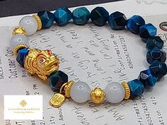 Gift yourself or your loveonce this exquisite Pure Gold Pixiu Bracelet.  *Materials: Au999, TIger's Eye Stone *Karat: 24K Pure Gold  *Gold Color: Yellow *Gold Weight: Approximately 2.47g *I-Ching Gold Ball: Approx. 6mm *Stone Size: Approximately 8 mn *Dragon Length: 16.9mm/.66  Inch 🧧Pi Xiu is capable of warding off evil spirits, bringing good fortune and wealth. ●NOT GOLD FILLED. NOT GOLD PLATED. NOT GOLD VERMEIL.  Metal is made of Real 24 Karat Gold . 📬S H I P P I N G Free shipping in the US and International orders. Spiritual Yellow Gold Beaded Bracelets As Gift, Spiritual Gold Bracelet With Round Beads As Gift, Gold Beaded Good Luck Bracelets, Elegant Handmade Bracelets For Blessing, Gold Bracelets With Round Beads For Good Luck, Traditional Gold Bracelets As Gifts, Traditional Yellow Gold Beaded Bracelets As Gift, Gold Spiritual Bracelets As Gifts, Traditional Gold Bracelet