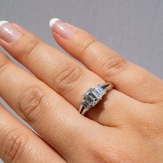 a woman's hand with a diamond ring on it