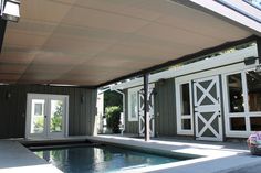 a house with a swimming pool in the middle and an awning over it's entrance