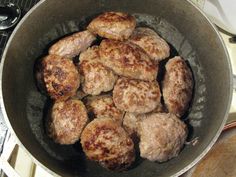 some meatballs are cooking in a pan on the stove