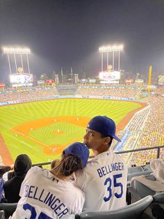 two baseball players sitting in the stands at a game