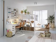 a white room with lots of furniture and plants on the desk in front of it