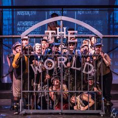 a group of people standing next to each other in front of a metal gate with the word hope written on it