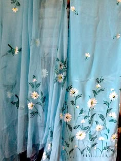 two blue curtains with white daisies on them