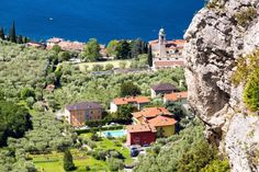 a small village nestled on the side of a cliff next to a body of water