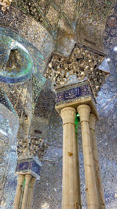 the inside of an ornate building with columns and chandeliers