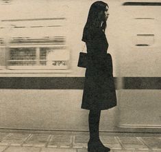 a woman standing in front of a train