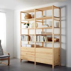 a living room with a chair, bookshelf and window