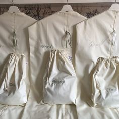 three white bags with embroidered name on them