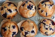 blueberry muffins sitting on top of a baking pan next to some berries