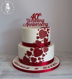 a white and red wedding cake with hearts on it