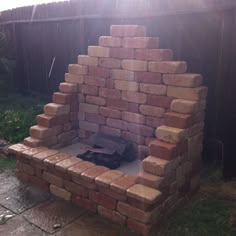 a fire pit made out of bricks in the backyard