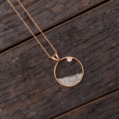 Surprise your special someone with this meteorite moonscape necklace!This pendant ishandcrafted in 14k rose gold and features a fragment of authentic Gibeon meteorite. A bezel-set moissanite accents the pendant's minimalist design. Wear a slice of the stars with this meteorite jewelry!This necklace includes a 16" Rose Gold Rope Chain.DETAILS OF THE PENDANT Metal: 14k Rose Gold Size: 16 mm x16 mm  Thickness: 3 mm  Bail Size: 3 mm x 5 mmStone: Forever One Moissanite Shape/Size: Round, 2 mm Setting Meteorite Wedding Rings, Meteorite Necklace, Gibeon Meteorite, Meteorite Jewelry, Engagement Rings Twisted, Moldavite Stone, Traditional Engagement Rings, Gold Pendant Jewelry, Diamond Fashion Rings