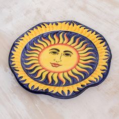 a ceramic plate with a sun face on it