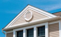 the top of a house with shutters and a clock on it's side