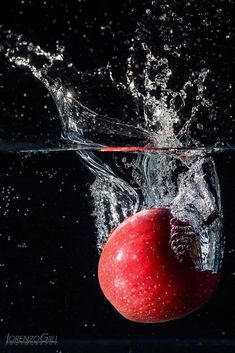 an apple is splashing into the water