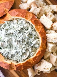 a bread bowl filled with spinach dip