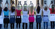 a group of women standing in front of a building holding up letters that spell out their name