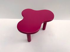 a pink table sitting on top of a white floor