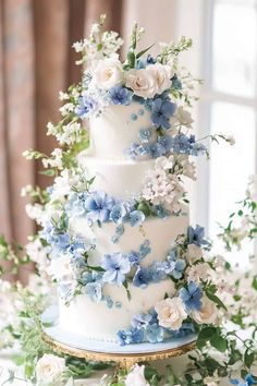 a wedding cake with blue and white flowers on it