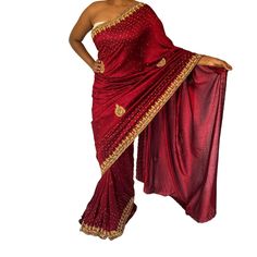 Elevate Your Party Attire With This Exquisite Maroon Saree, Designed To Captivate With Its Rich Color And Intricate Detailing. Crafted For Elegance And Allure, The Saree Drapes Beautifully In Luxurious Maroon Fabric, Offering A Perfect Blend Of Comfort And Sophistication. Adorning The Saree Is Delicate Embellishment, Adding A Touch Of Glamour And Sparkle. Accompanying This Saree Is An Unstitched Blouse Piece, Providing You The Freedom To Personalize The Fit And Design According To Your Preferences. Whether For Weddings, Receptions, Or Festive Celebrations, This Ensemble Promises To Make A Statement With Its Impeccable Craftsmanship And Timeless Appeal. Saree Drapes, Maroon Saree, Maroon Fabric, Weddings Receptions, Party Attire, Party Wear Saree, Wear Saree, Party Wear Sarees, Blouse Piece