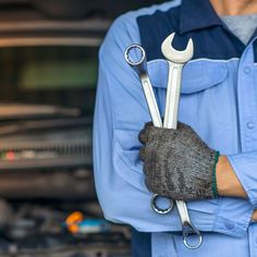 a mechanic holding two wrenches in his hands