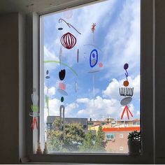 there is a window with many different objects on it in front of the sky and clouds