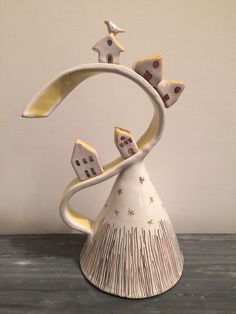 a white vase sitting on top of a wooden table