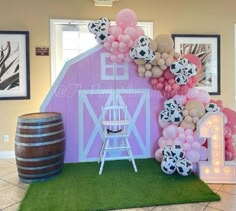 a pink barn decorated with balloons and decorations