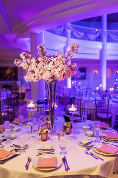 the tables are set with place settings and centerpieces for an elegant wedding reception