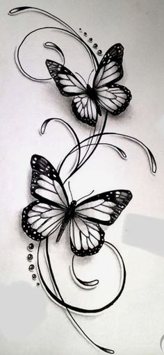 two butterflies flying on top of a white sheet with black ink and some writing underneath it