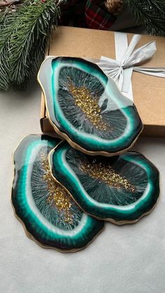 three green and gold plates sitting on top of a table next to a christmas tree