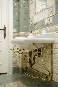 a white sink sitting under a bathroom mirror next to a wall mounted faucet