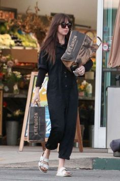 a woman is walking down the street carrying shopping bags