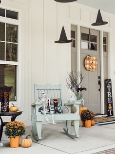 a porch decorated for halloween with pumpkins and decorations