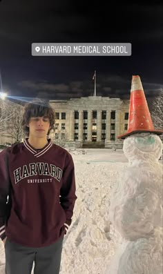 a young man standing next to a snowman in front of a building with a sign that says harvard medical school