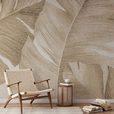 a chair and table in front of a wall with a large leaf pattern on it