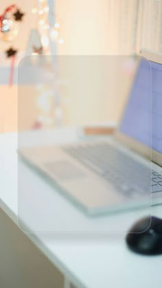 an open laptop computer sitting on top of a white desk next to a black mouse