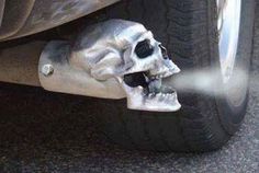 a silver skull is spraying water on the side of a car's front tire