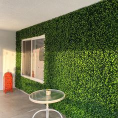 a table and chair in front of a green wall