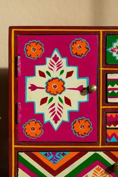 a colorful painted dresser with drawers and knobs