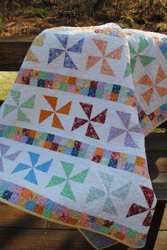 two quilts are sitting on a wooden bench