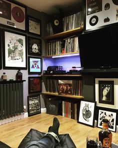 there is a man laying on the floor in front of a tv and bookshelf