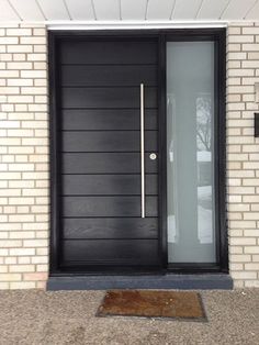 a dog is standing in front of a black door