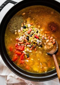 a pot filled with soup and beans on top of a table